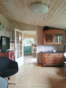 eine Küche mit Holzschränken, einem Tisch und einem TV in der Unterkunft Stranda apartment in Stranda