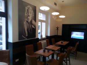 a restaurant with wooden tables and chairs and a tv at Bona Serva in Prague