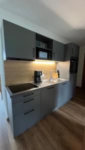 a kitchen with a sink and a microwave at Alpenresidenz M Vermietungs KG in See