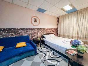 um quarto com uma cama e um sofá azul em Guest House on Saksahanskoho Street em Kiev