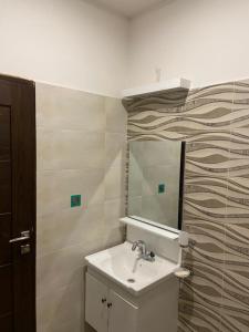 ein Bad mit einem Waschbecken und einem Spiegel in der Unterkunft The River View Apartment in Rawalpindi