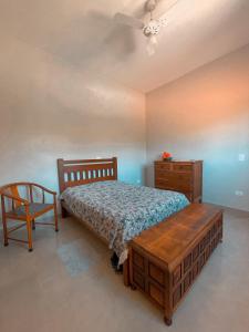 a bedroom with a bed and a dresser and a chair at Chácara Águas São Pedro in Águas de São Pedro