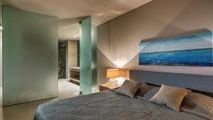 a bedroom with a bed and a painting on the wall at Private 3 Br Luxury Peaceful Mylo Villa W Pool Close to Mylopotas Beach in Ios Chora