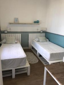 two twin beds in a room with a table at Angatu Hostel in Sao Paulo