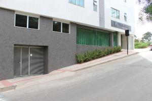 a building with a green door on the side of it at Vertentes Suítes Hotel in Conselheiro Lafaiete