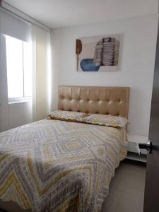 1 dormitorio con 1 cama con manta y ventana en Hermoso apartamento con zona social, en Los Patios