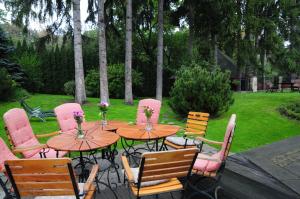 drewniany stół i krzesła z kwiatami na patio w obiekcie Pensjonat Willa w Parku w Polanicy Zdroju