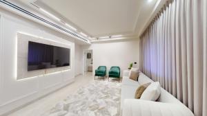 a living room with a white couch and a tv at A luxury apartment in the center of Jerusalem in Jerusalem