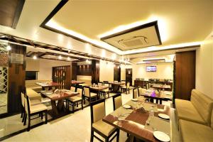 a restaurant with tables and chairs in a room at Hotel Palm Bliss International in Dānāpur