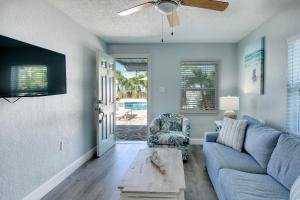 a living room with a blue couch and a ceiling fan at The Bungalows in St Pete Beach