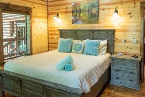 1 dormitorio con 1 cama grande en una cabaña de madera en Broken Bow Cabin with Hot Tub and Outdoor Fireplace! en Broken Bow