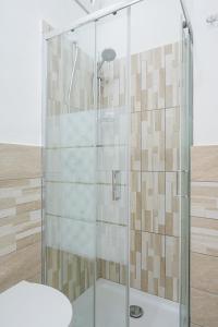 y baño con ducha y puerta de cristal. en Design Suite in the heart of Bicocca University, en Milán