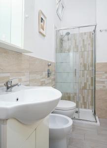 La salle de bains blanche est pourvue d'un lavabo et de toilettes. dans l'établissement Design Suite in the heart of Bicocca University, à Milan