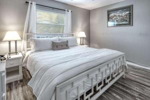 Un dormitorio con una gran cama blanca y una ventana en Sunset Beach Suites en St Pete Beach