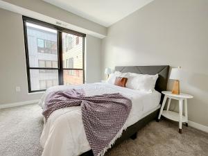 a white bedroom with a bed and a window at Sleepover Premier Downtown Des Moines Apartments in Des Moines +188 photos