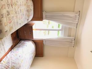 a small bedroom with a bunk bed and a window at Chateau du Loire Apartamento in Campos do Jordão