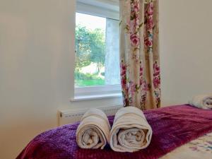 łóżko z ręcznikami i oknem w obiekcie Cornel Clyd cosy Corner w mieście Cilcennin