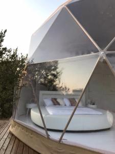 Posto letto in una tenda in vetro con un letto. di Domo Suites Masía Cal Geperut a Badalona