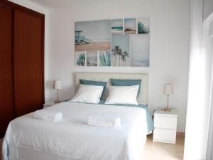 a bedroom with a white bed with two pillows at Casa Azul in Praia da Areia Branca