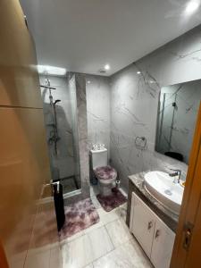Un baño con inodoro, lavabo y ducha. en PALACE B Av Hassan II Marrakech 40000 -Brand New Luxury UNIT#2 & UNIT#29, en Marrakech