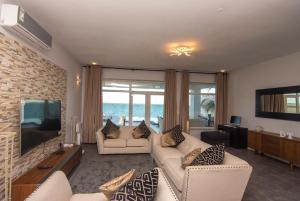 a living room with two white couches and a television at Zanzibar DT Beachfront Villa in Mkunguni