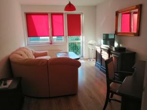 a living room with red windows and a couch at Grzyminska in Szczecin