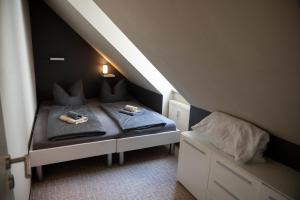a small bedroom with two beds in a attic at Harznester - Ferienhaus am Thie in Blankenburg