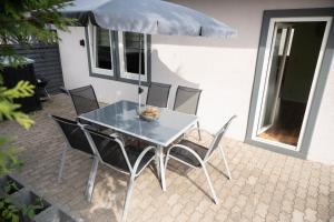 a table with chairs and an umbrella on a patio at Harznester - Ferienhaus am Thie in Blankenburg