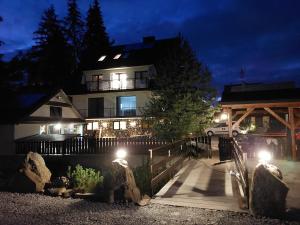 a house at night with lights in front of it at Noclegi nad potokiem in Witów