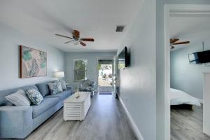 a living room with a blue couch and a ceiling fan at The Bungalows in St. Pete Beach