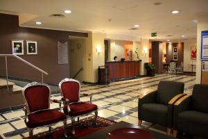 a lobby with a waiting area with chairs and a couch at Hotel Orquidea in Funchal