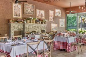 uma sala de jantar com mesas e cadeiras brancas e uma lareira em Fiesta Americana Hacienda Galindo Resort & Spa em Galindo