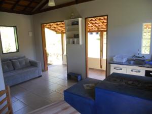 Chalés Serrinha do Papagaio في أيوريوكا: غرفة معيشة مع أريكة ومطبخ
