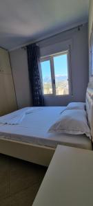 a bedroom with a large bed with a window at Luis Penthouse in Berat