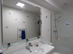 La salle de bains blanche est pourvue d'un lavabo et d'un miroir. dans l'établissement CASA EGIPCIA Preciosa casa centenaria en el Camino de Santiago, à Torres del Río
