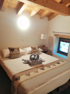 a bedroom with a bed with a bow on it at Casa Alpina San Luigi in Campodolcino