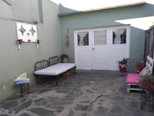 a patio with a white door and a bench at Aquí te Espero in Tandil