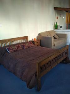a bedroom with a large bed and a couch at Aquí te Espero in Tandil