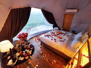 a bedroom with a bed with flowers on the floor at Jewelberry Glamping Hotel Tbilisi in Mtskheta