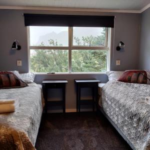 維克的住宿－Prestshús 2 Guesthouse，一间卧室设有两张床和窗户。