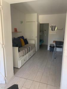 ein Wohnzimmer mit einem Bett in einem weißen Zimmer in der Unterkunft PORTISSOL in Sanary-sur-Mer
