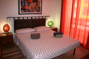 a bedroom with a bed and two lamps and a window at Casa Bahia 4 in Santa Maria