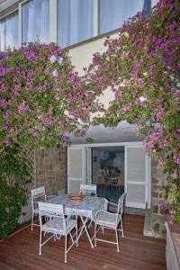 a table and chairs on a patio with purple flowers at Cottage Punta Ala Residential Area with Pool in Punta Ala