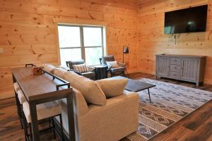 sala de estar con sofá y TV de pantalla plana en Woodland Cove en Waldens Creek