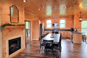 a kitchen and dining room with a fireplace in a log cabin at Woodland Cove in Waldens Creek