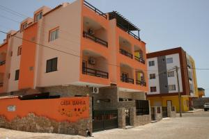聖瑪麗亞的住宿－Casa Bahia 4，一座橙色和白色的建筑,上面有标志