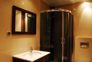 Un baño con lavabo y ducha con espejo. en Władysławowo Apartament Morska, en Władysławowo 22 fotos más