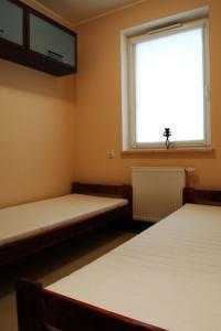 una habitación con dos camas y una ventana en Władysławowo Apartament Morska, en Władysławowo