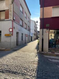 une rue pavée dans une ruelle entre deux bâtiments dans l'établissement Hotel Isabel, à Briviesca