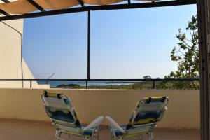 2 Stühle auf einem Balkon mit Meerblick in der Unterkunft Villa Sunset in Boghaz